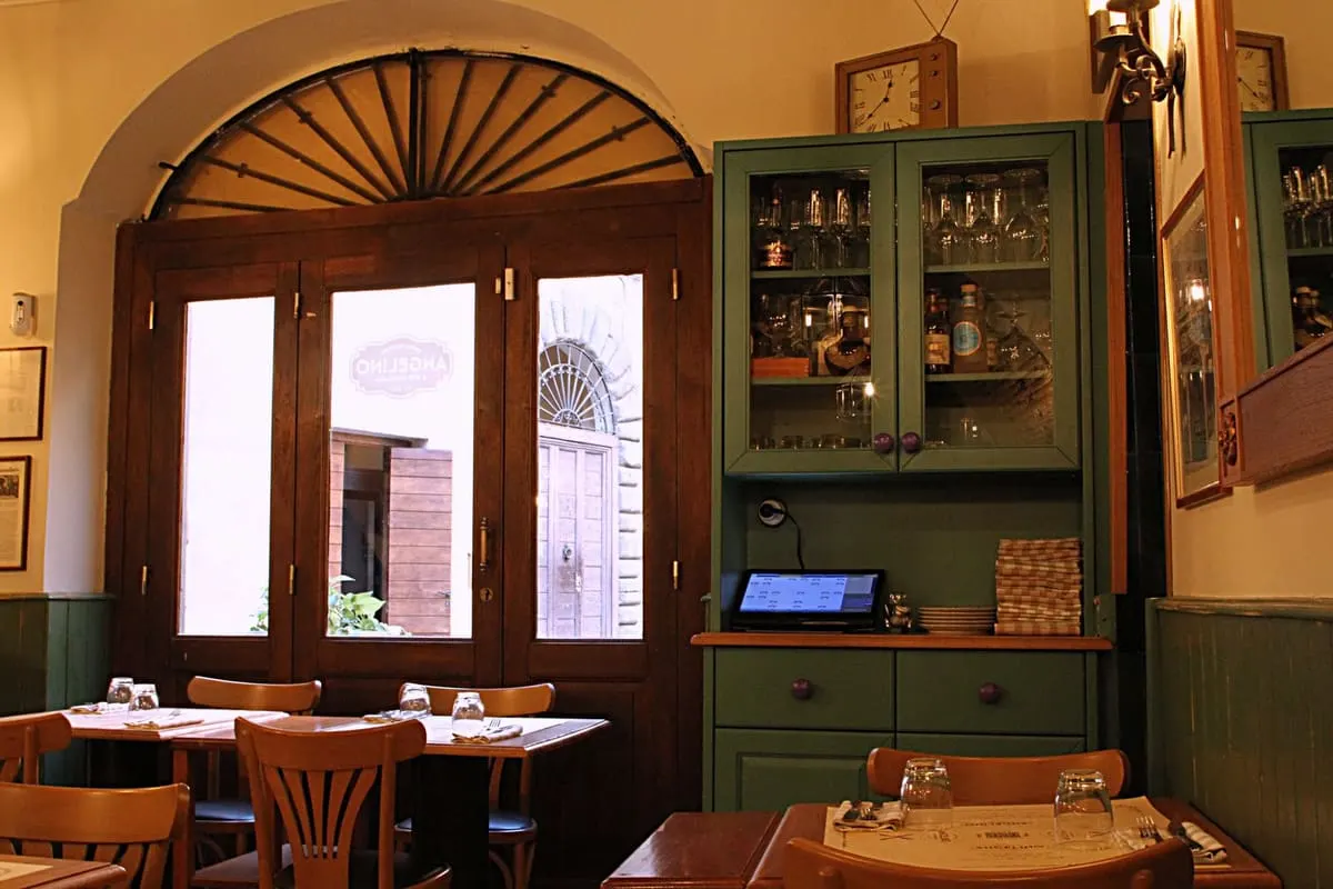 La sala dell’osteria, legno e luce calda